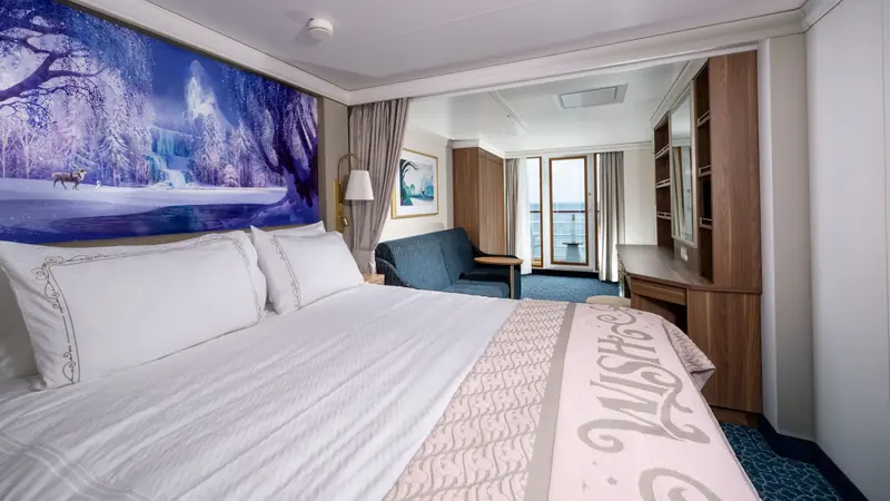 Cabine com cama de casal, mural temático na parede e porta para a varanda