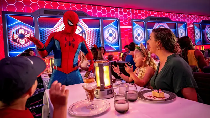 Famílias em um restaurante temático iluminado, com show de personagem