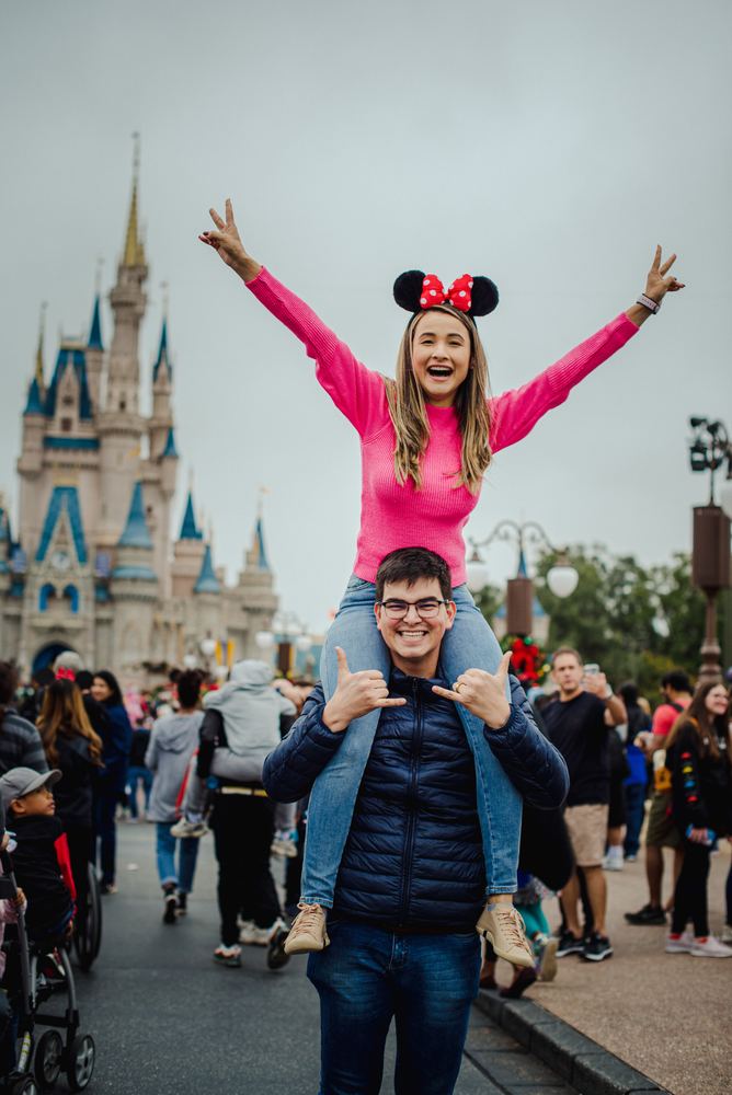 Menina nos ombros do pai comemorando em frente ao castelo