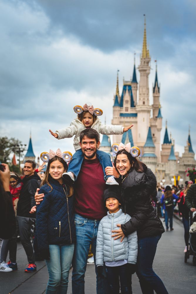 Família de clientes posando em frente ao castelo